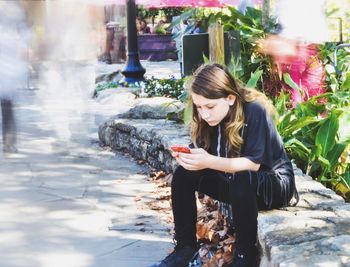 Young woman sitting outdoors