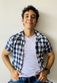 Portrait of young man standing against wall