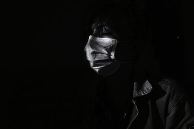 Portrait of man against black background