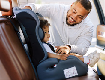 Man with toddler son sitting in car