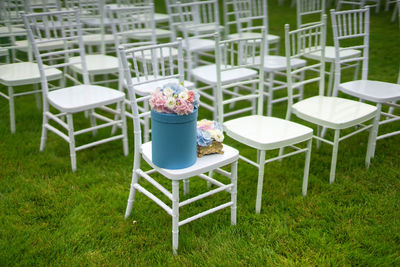 Empty chairs and table on field