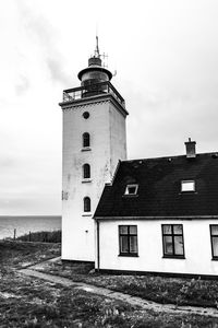 Lighthouse amidst buildings against sky