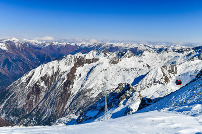 Scenic view of snowcapped mountains against blue sky