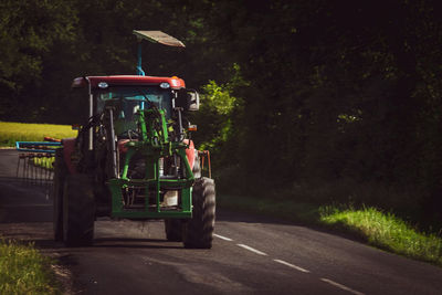 Tractor on road amidst field