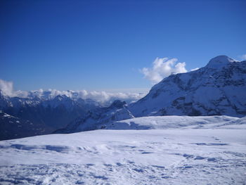 Scenic view of snowcapped mountains against blue sky