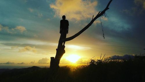 Silhouette man standing against sky during sunset