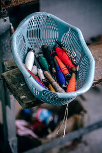 Close-up of multi colored thread spools in basket on table