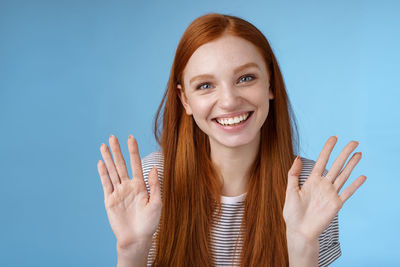 Portrait of smiling young woman against gray background