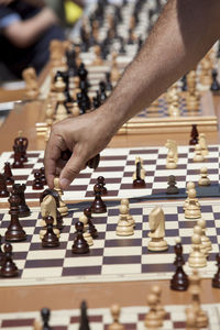 Cropped hand of man playing chess on table