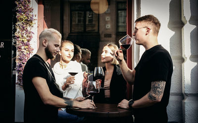 Cheerful couples enjoying drink while standing at restaurant