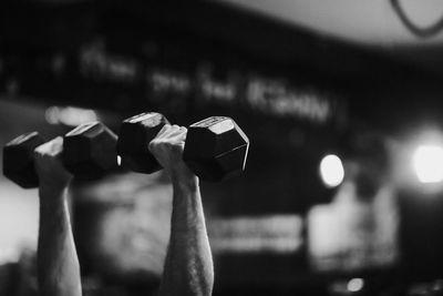 Cropped hands of man lifting dumbbells