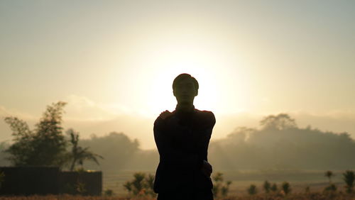 Silhouette man standing against sky during sunrise