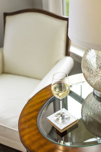 Close-up of wine glass full of white wine on side table, luxurious lifestyle
