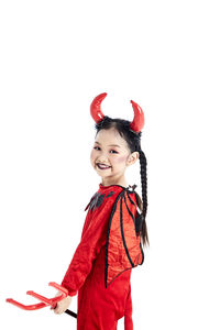 Portrait of smiling girl standing against white background