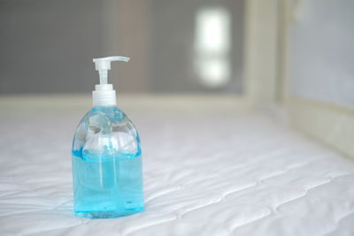 Close-up of glass bottle on bed