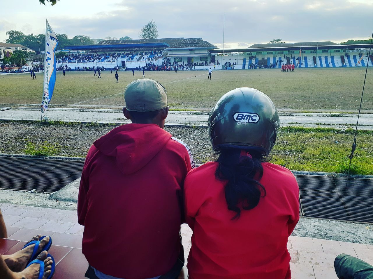 REAR VIEW OF MAN AND WOMAN STANDING AGAINST RED SKY