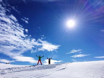 People on snow against blue sky