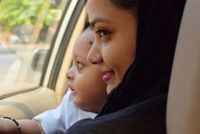 Close-up of mother with baby in car