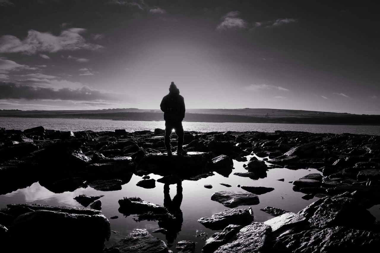 water, sea, sky, silhouette, horizon over water, tranquility, scenics, tranquil scene, cloud - sky, nature, beauty in nature, beach, shore, cloud, standing, rock - object, lifestyles, men