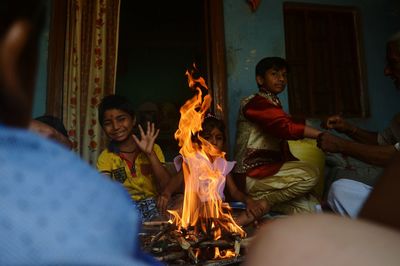 People sitting by fire at home