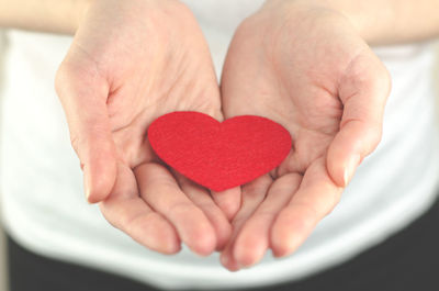 Red heart in female palms on a white background.the concept of love, health or world peace