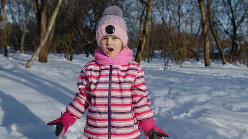 Full length of girl standing on snow covered field