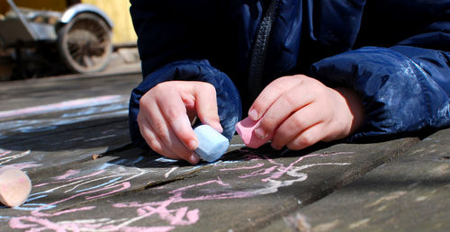 Close-up of child drawing on asphalt