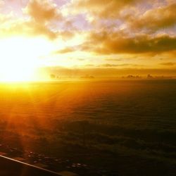 Scenic view of sea against cloudy sky during sunset