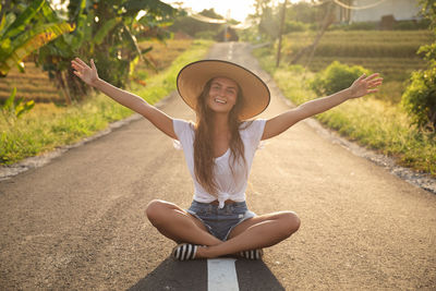Portrait of young woman exercising on road