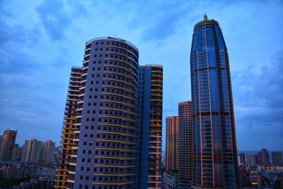 Low angle view of buildings against cloudy sky