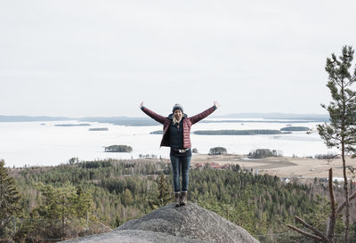 Woman jumping for joy as she reaches the top of a hill climbing