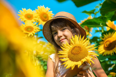 Portrait of woman holding yellow flower