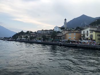 River by buildings in city against sky