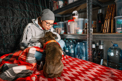 Man and french bulldog dog bonding in underground emergency shelter