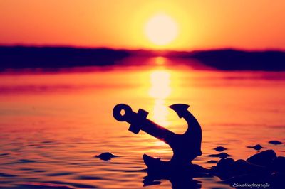 Silhouette person against sea during sunset