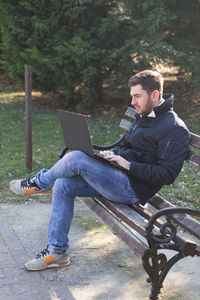 Side view of young man using mobile phone