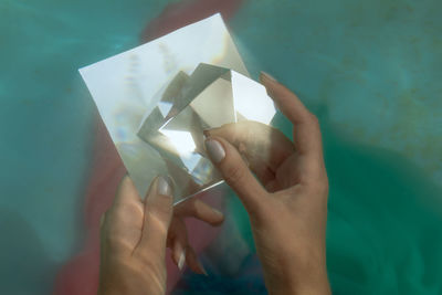 Cropped hands of woman holding prism