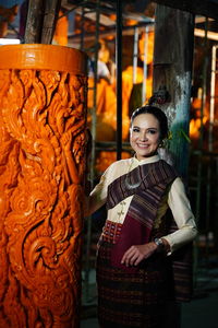 Portrait of smiling woman wearing traditional clothing at night