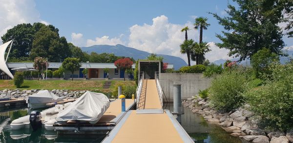 Panoramic view of swimming pool by buildings against sky