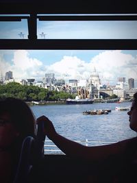 Boats in river with city in background