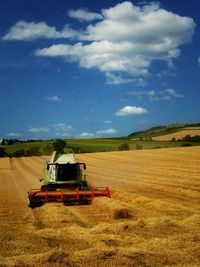 Scenic view of field against cloudy sky