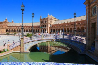 People walking in arch bridge at plaza de espana