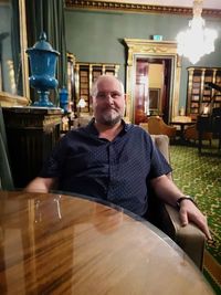 Portrait of man sitting on table