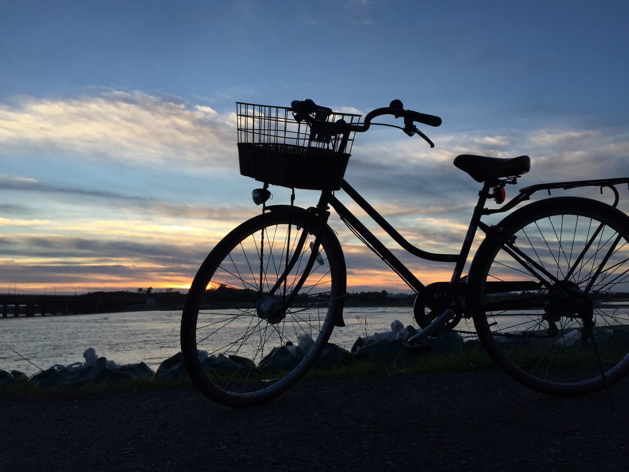 bicycle, transportation, mode of transport, water, sky, land vehicle, sunset, stationary, parking, silhouette, parked, sea, cloud - sky, river, railing, tranquility, tranquil scene, outdoors, nautical vessel, travel