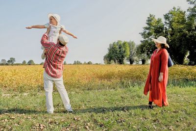 Full length of woman standing on field against sky