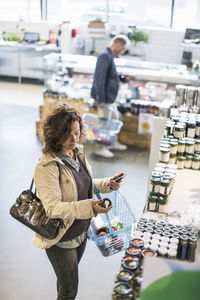 High angle view of mature man and woman shopping in supermarket