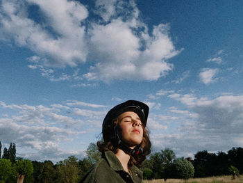 Portrait of teenage girl looking away against sky