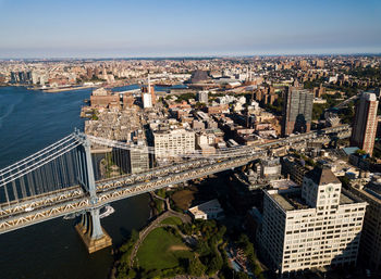 High angle view of manhattan bridge over river by buildings against sky