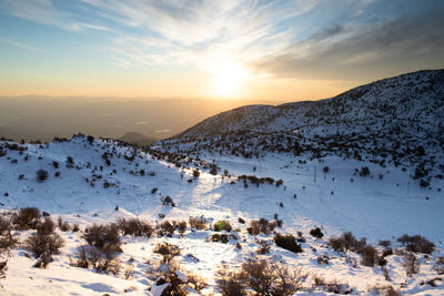 Scenic view of snowcapped mountains against sky during sunset