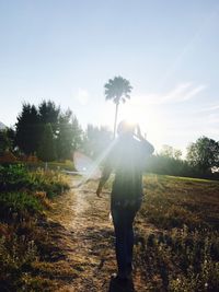 Man standing by tree against sky